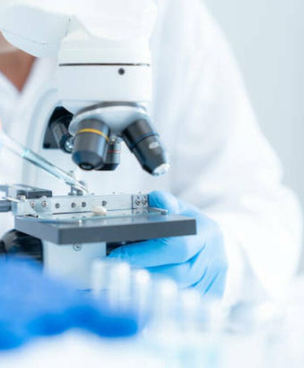 Contact home img Laboratory technician examining a sample under a microscope at Stem Cell Medellin